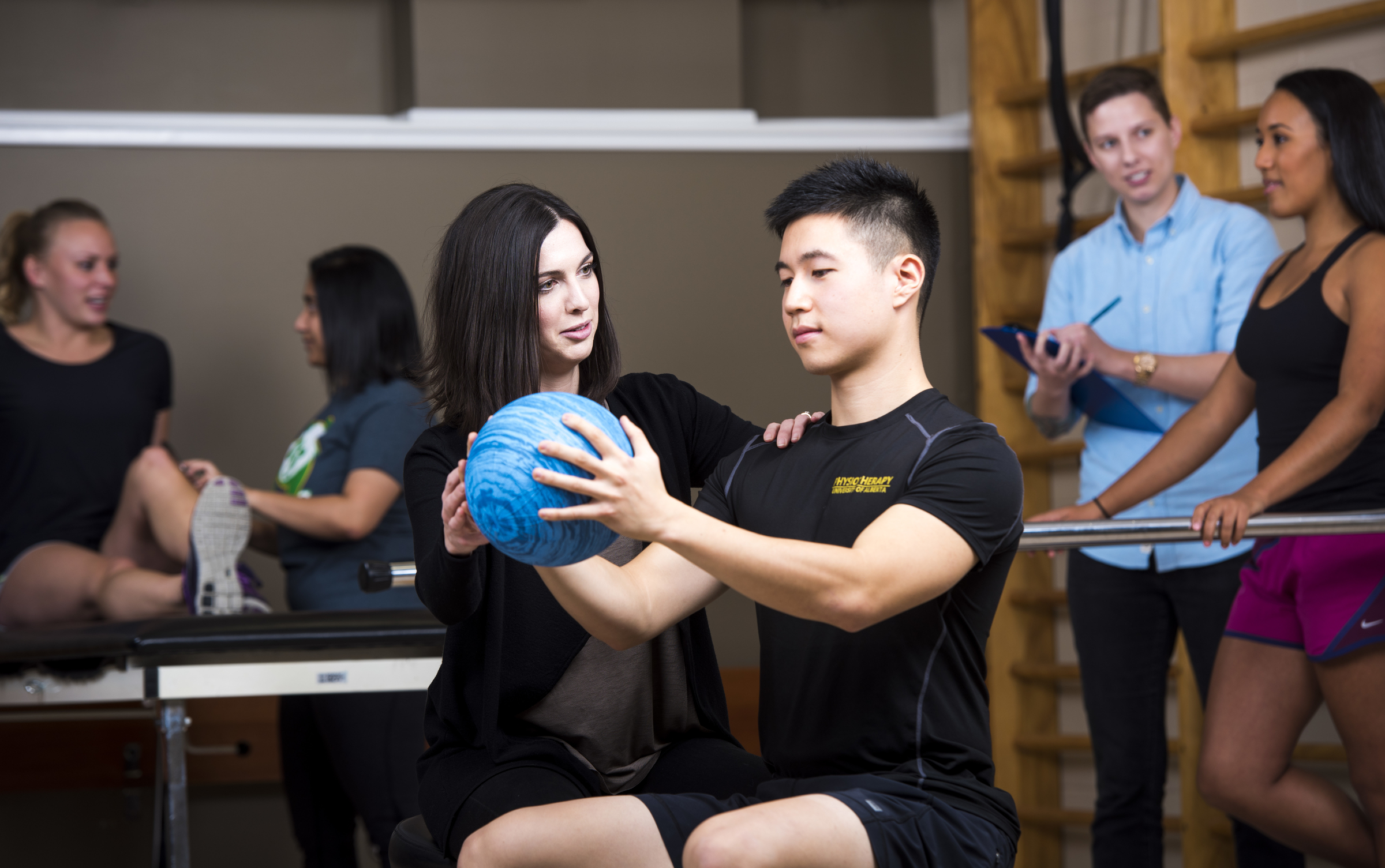 Woman helping a man hold a ball
